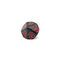 Close up of a single black speckled percentile d10 die with red numbers
