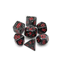 Set of black polyhedral dice with red numbers on a white background