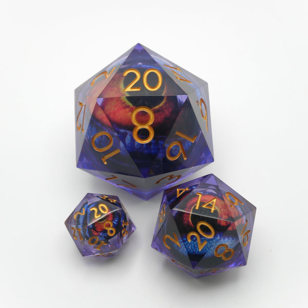 Three translucent purple polyhedral dice with gold-colored numerals and a red and blue eye design inside, displayed on a clean white background.