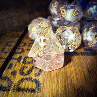 Set of polyhedral dice with gold numbers on a wooden surface