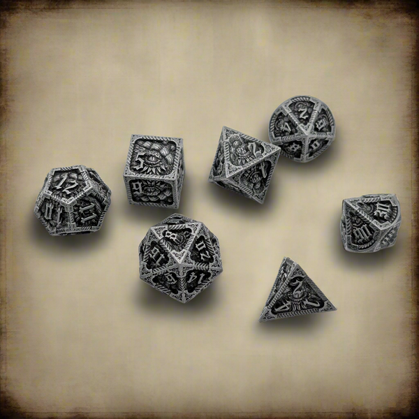 A set of seven silver-toned polyhedral RPG dice with dark engraved details and occult symbols, arranged on a textured beige parchment background.