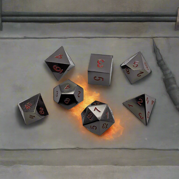 A set of reflective silver polyhedral tabletop gaming dice with red numbers, arranged on a gray stone surface with one die showing a glowing orange flame effect.