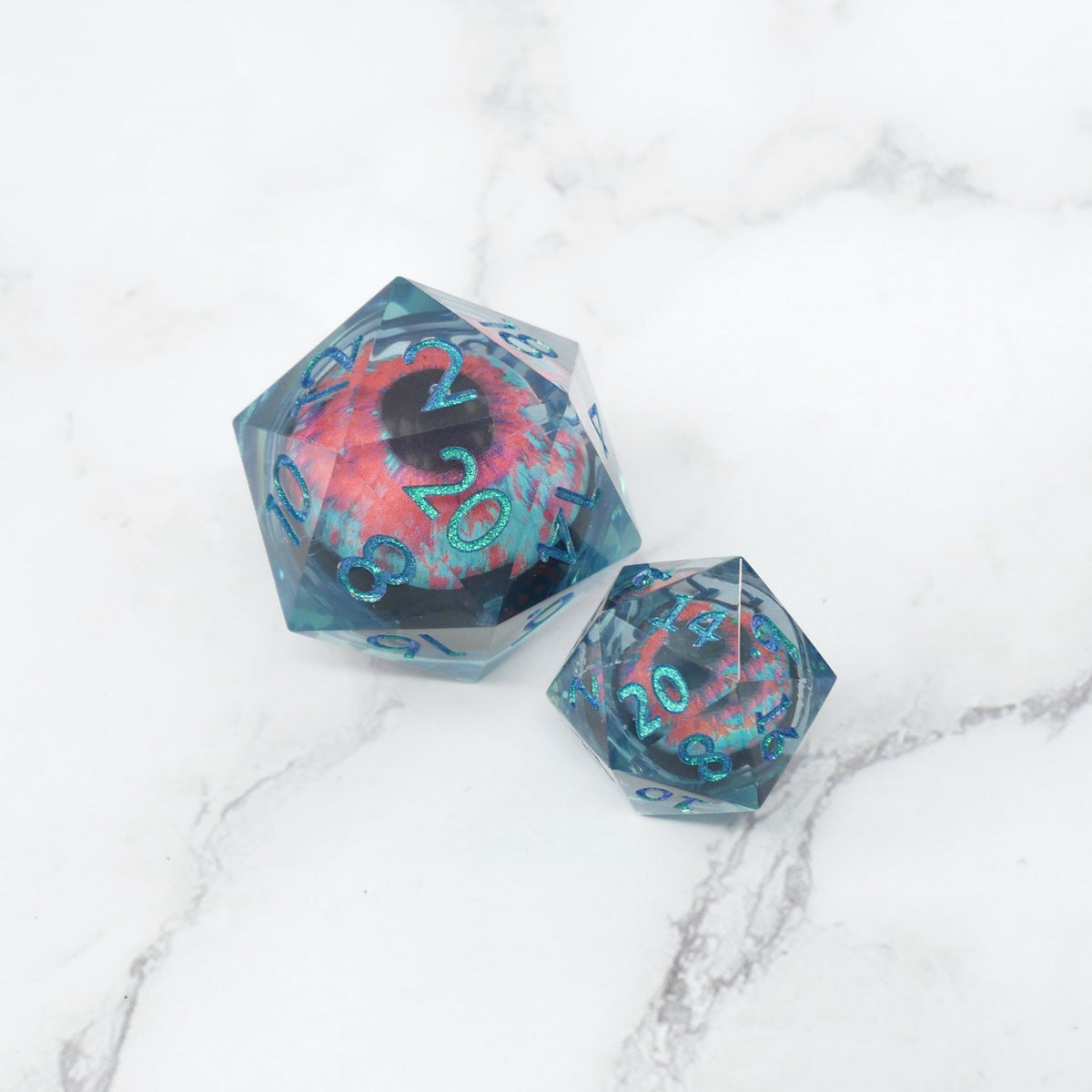 Two polyhedral dice with a colorful design on a marble surface
