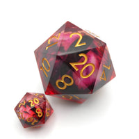 Two polyhedral dice with red and black marbled pattern and gold numbers on a white background
